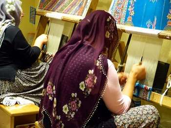 Halı dokuma tezgahı ve el dokuması halı yapan kadınlar